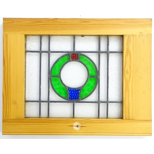 1261 - A pair of 20thC stained glass panels with green, red and blue roundel detail. Approx. 23 3/4