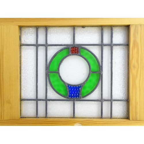 1261 - A pair of 20thC stained glass panels with green, red and blue roundel detail. Approx. 23 3/4