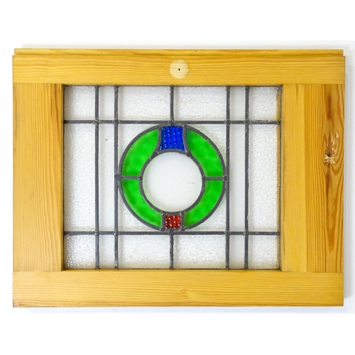 1261 - A pair of 20thC stained glass panels with green, red and blue roundel detail. Approx. 23 3/4