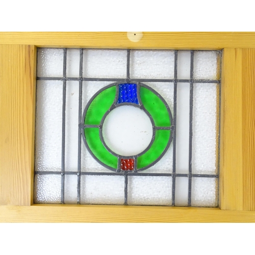 1261 - A pair of 20thC stained glass panels with green, red and blue roundel detail. Approx. 23 3/4