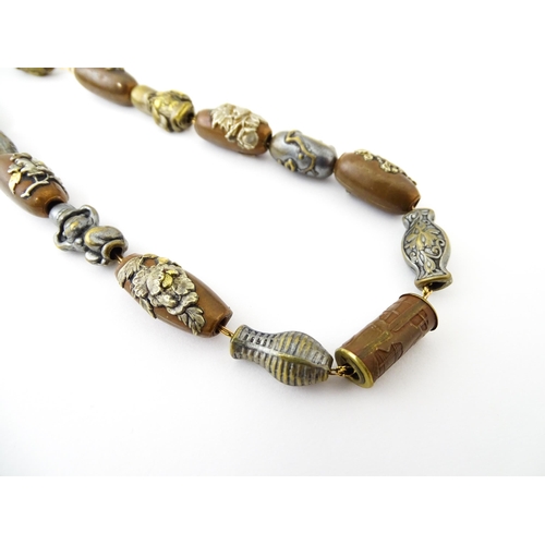 670 - A yellow metal necklace set with 15 Japanese ojime beads, with various decoration to include floral ... 