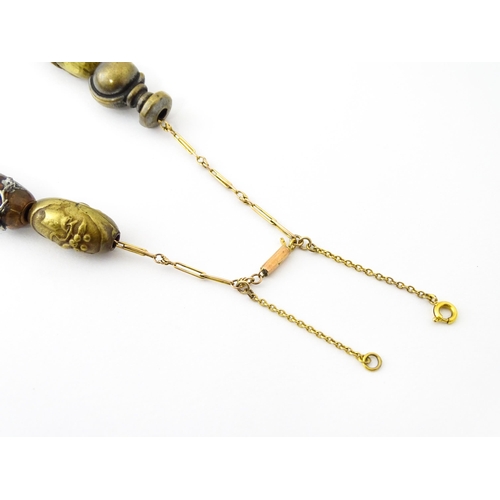 670 - A yellow metal necklace set with 15 Japanese ojime beads, with various decoration to include floral ... 