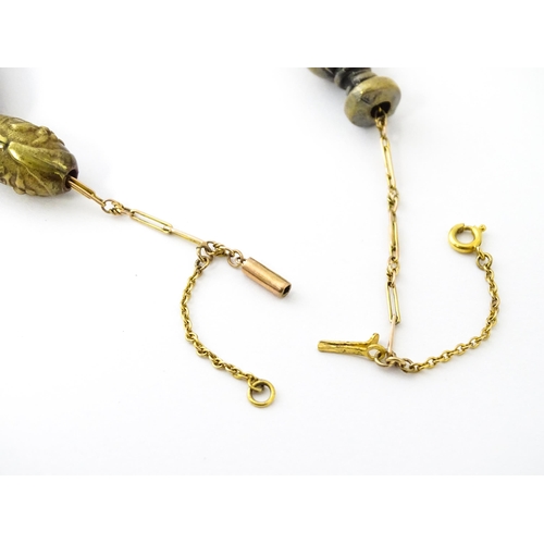 670 - A yellow metal necklace set with 15 Japanese ojime beads, with various decoration to include floral ... 