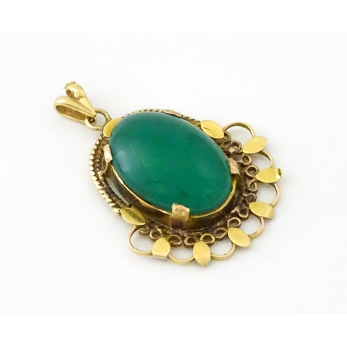 674 - A yellow metal pendant set with central green cabochon. Approx. 1 1/4