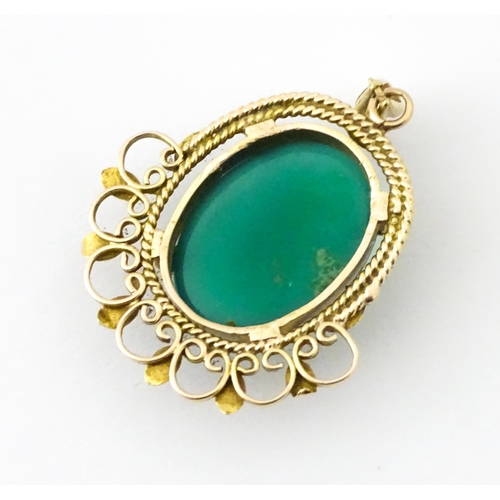 674 - A yellow metal pendant set with central green cabochon. Approx. 1 1/4