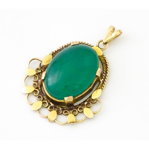 674 - A yellow metal pendant set with central green cabochon. Approx. 1 1/4