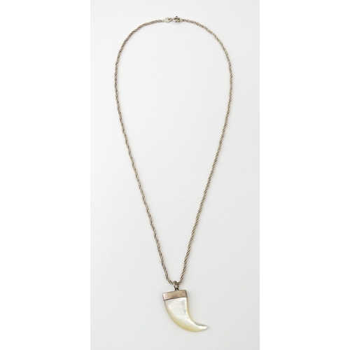 676 - A silver necklace with mother of pearl and silver mounted pendant of tiger claw form. Pendant approx... 