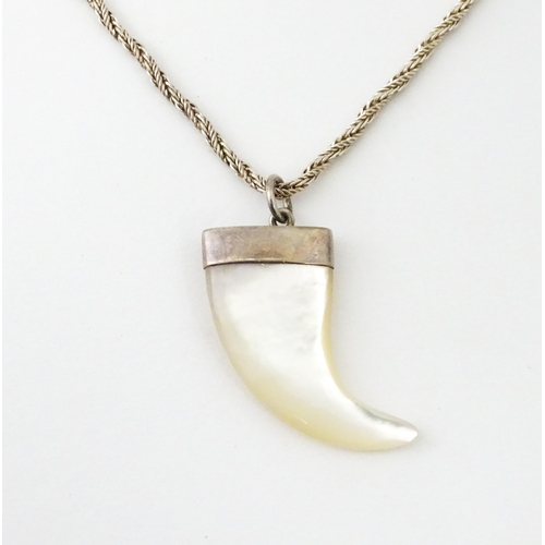 676 - A silver necklace with mother of pearl and silver mounted pendant of tiger claw form. Pendant approx... 