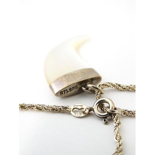 676 - A silver necklace with mother of pearl and silver mounted pendant of tiger claw form. Pendant approx... 