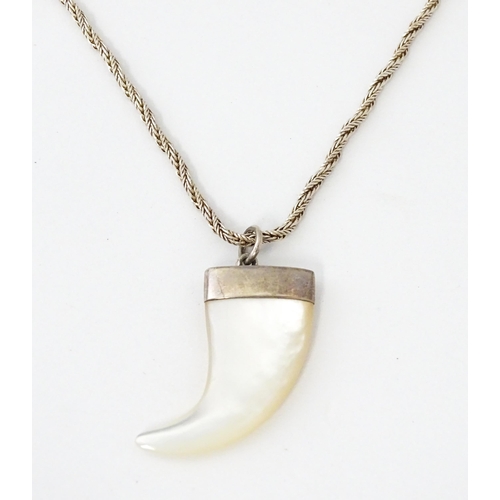 676 - A silver necklace with mother of pearl and silver mounted pendant of tiger claw form. Pendant approx... 