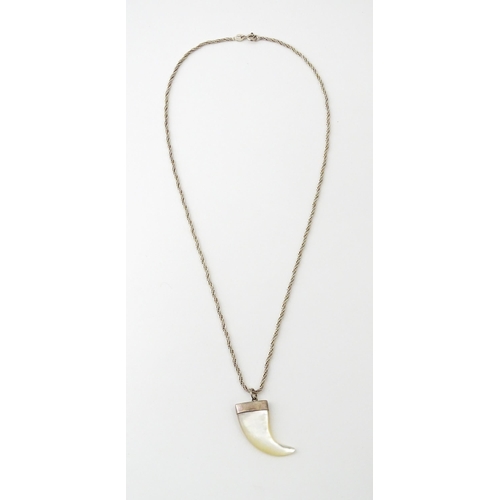 676 - A silver necklace with mother of pearl and silver mounted pendant of tiger claw form. Pendant approx... 