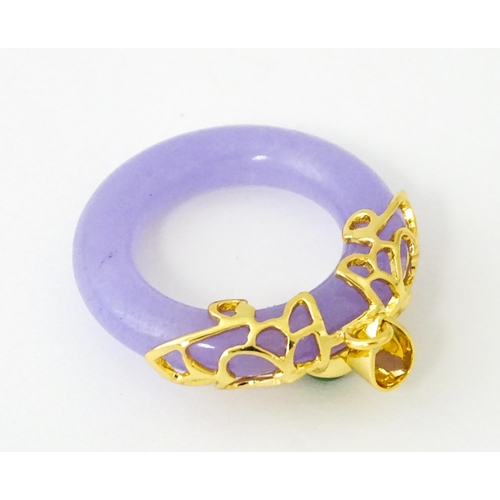 677 - A pendant with gilt metal mounts and purple coloured jade like ring detail. 1 1/2