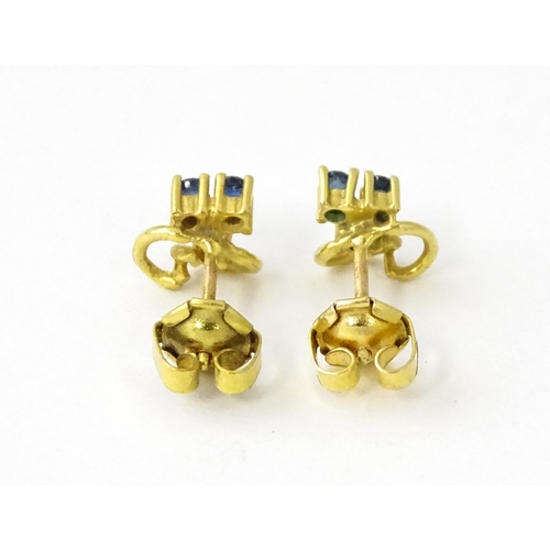 678 - A pair of 9ct gold stud earrings set with blue stones