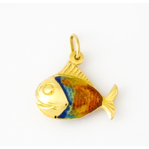 679 - An 18ct gold pendant / charm formed as a fish with enamel detail. Approx. 3/4