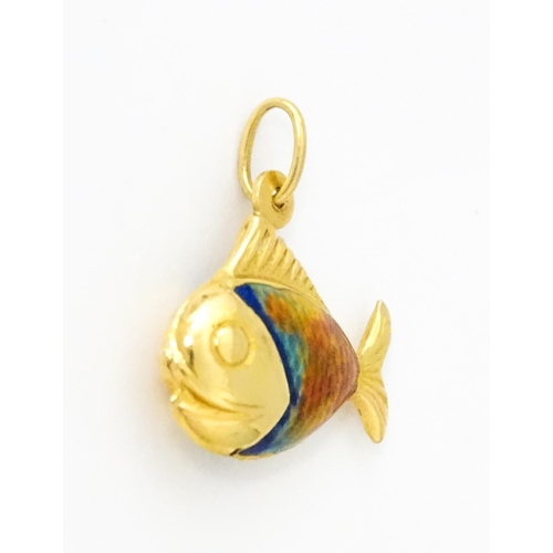 679 - An 18ct gold pendant / charm formed as a fish with enamel detail. Approx. 3/4