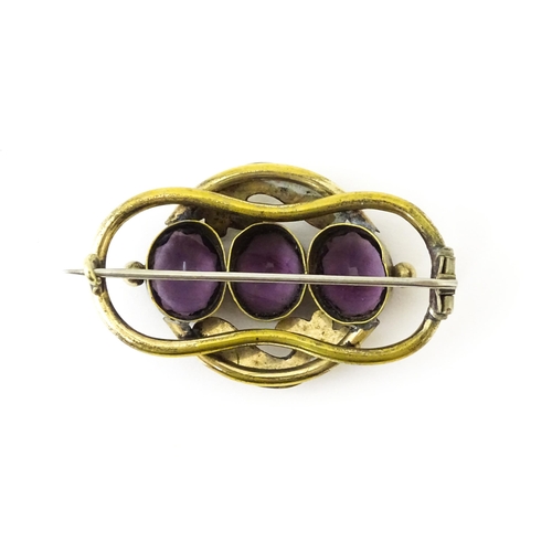 680 - A gilt metal brooch set with three purple coloured stones. Approx. 2