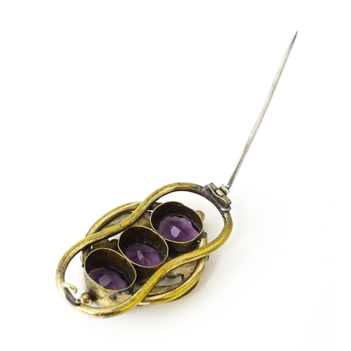 680 - A gilt metal brooch set with three purple coloured stones. Approx. 2