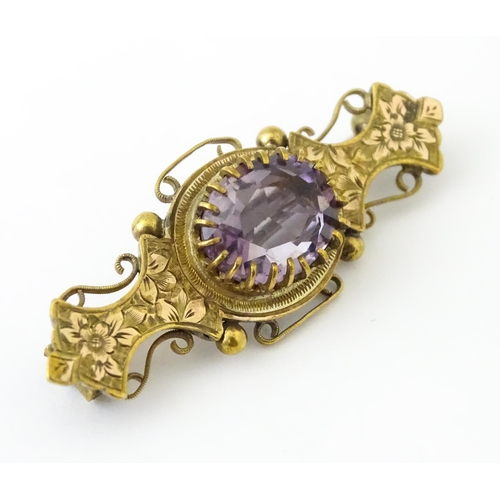 694 - A yellow metal brooch set with central amethyst. Approx. 1 3/4