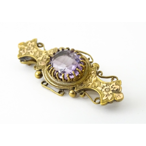 694 - A yellow metal brooch set with central amethyst. Approx. 1 3/4