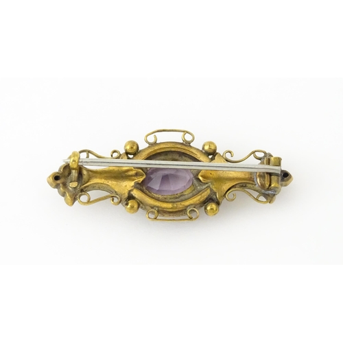 694 - A yellow metal brooch set with central amethyst. Approx. 1 3/4