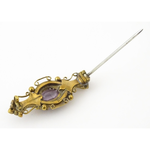 694 - A yellow metal brooch set with central amethyst. Approx. 1 3/4