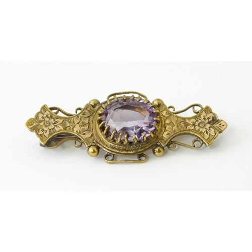 694 - A yellow metal brooch set with central amethyst. Approx. 1 3/4