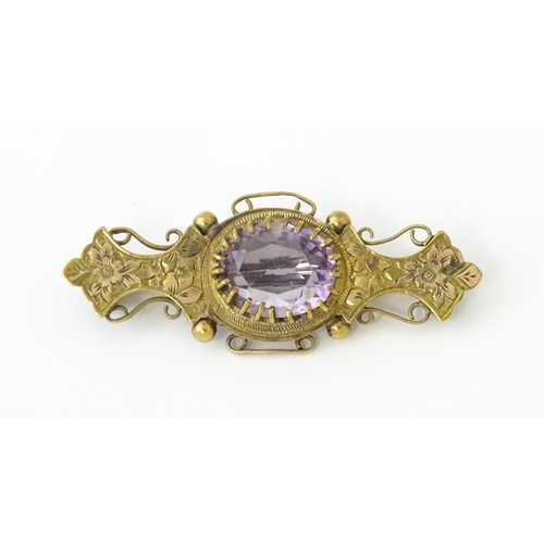 694 - A yellow metal brooch set with central amethyst. Approx. 1 3/4