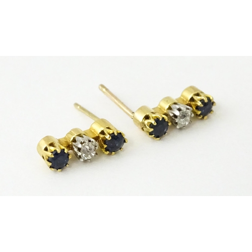 697 - A pair of 9ct gold earrings set with diamonds and blue stones. Approx. 1/2