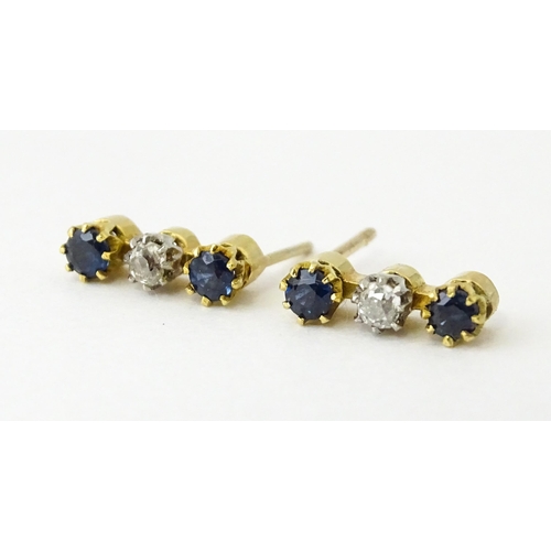 697 - A pair of 9ct gold earrings set with diamonds and blue stones. Approx. 1/2