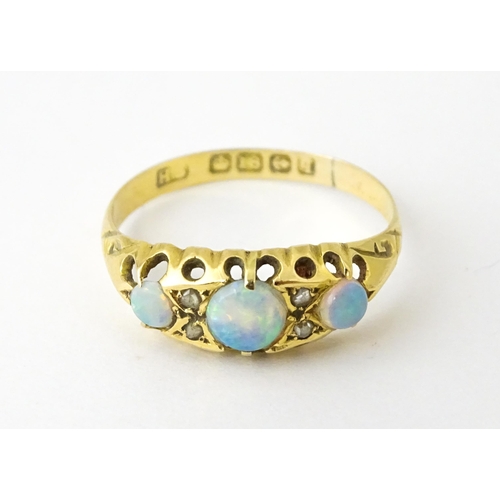 703 - An 18ct gold ring set with opals and diamonds. Hallmarked Birmingham 1915. Ring size approx. N