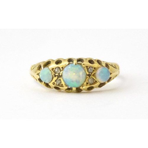 703 - An 18ct gold ring set with opals and diamonds. Hallmarked Birmingham 1915. Ring size approx. N