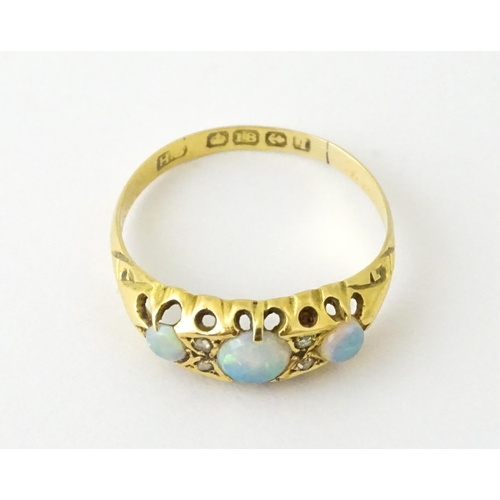 703 - An 18ct gold ring set with opals and diamonds. Hallmarked Birmingham 1915. Ring size approx. N