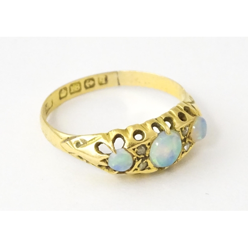 703 - An 18ct gold ring set with opals and diamonds. Hallmarked Birmingham 1915. Ring size approx. N