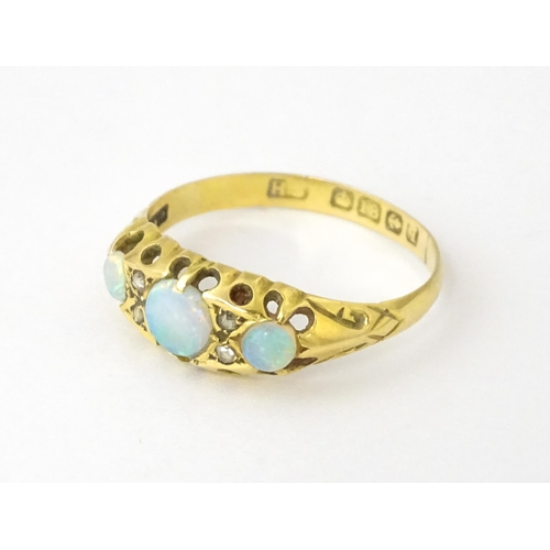 703 - An 18ct gold ring set with opals and diamonds. Hallmarked Birmingham 1915. Ring size approx. N