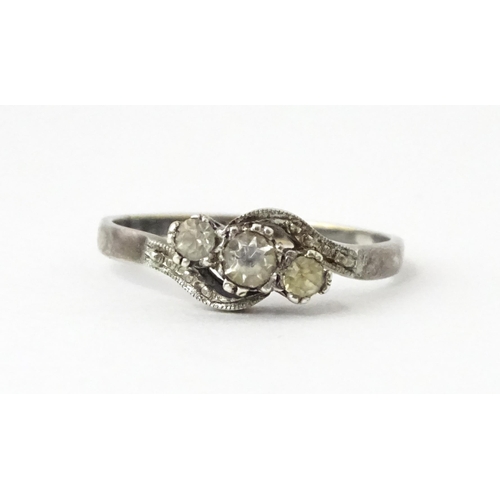 705 - A 9ct gold and silver ring set with three white stones in a twist setting. Ring size approx. O