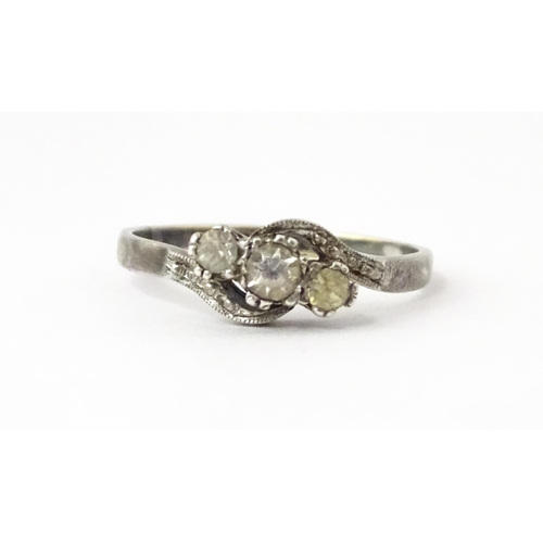 705 - A 9ct gold and silver ring set with three white stones in a twist setting. Ring size approx. O