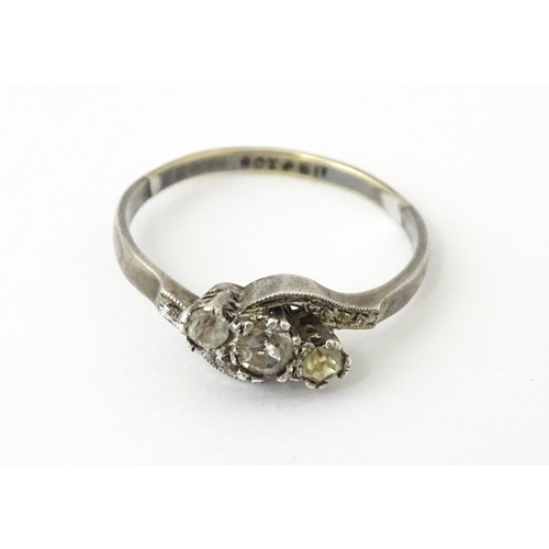 705 - A 9ct gold and silver ring set with three white stones in a twist setting. Ring size approx. O