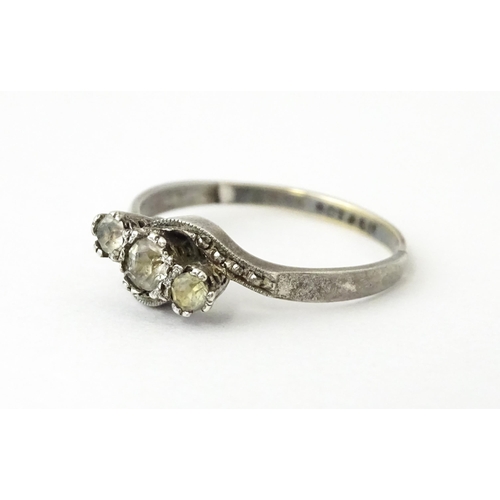 705 - A 9ct gold and silver ring set with three white stones in a twist setting. Ring size approx. O