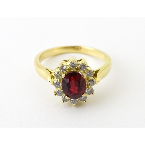 706 - An 18ct gold ring set with central ruby bordered by diamonds. Ring size approx. H 1/2