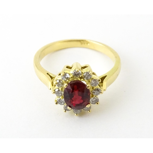 706 - An 18ct gold ring set with central ruby bordered by diamonds. Ring size approx. H 1/2