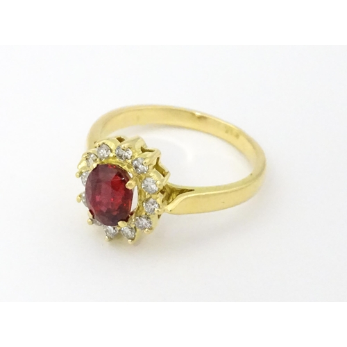 706 - An 18ct gold ring set with central ruby bordered by diamonds. Ring size approx. H 1/2