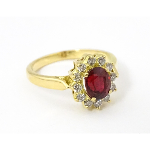 706 - An 18ct gold ring set with central ruby bordered by diamonds. Ring size approx. H 1/2