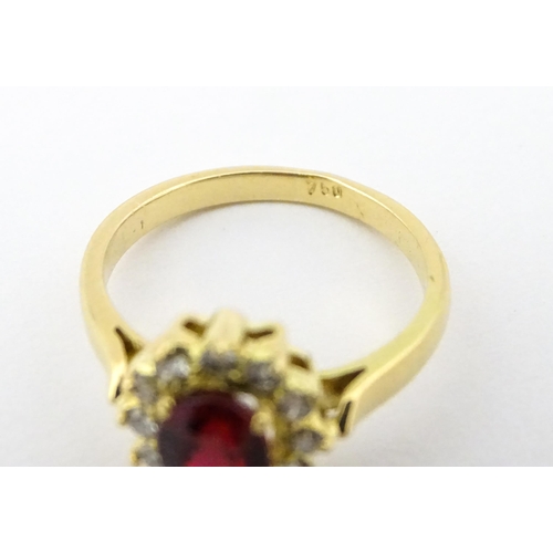 706 - An 18ct gold ring set with central ruby bordered by diamonds. Ring size approx. H 1/2