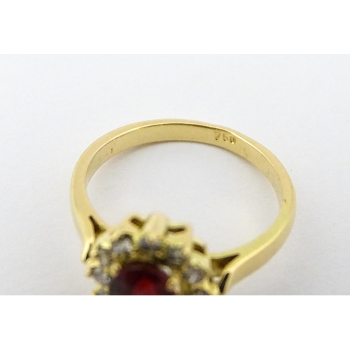 706 - An 18ct gold ring set with central ruby bordered by diamonds. Ring size approx. H 1/2