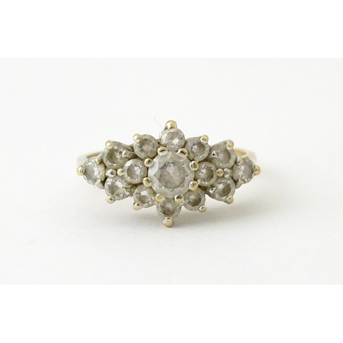 712 - A 9ct gold ring set with cluster of white stones. Ring size approx. J 1/2