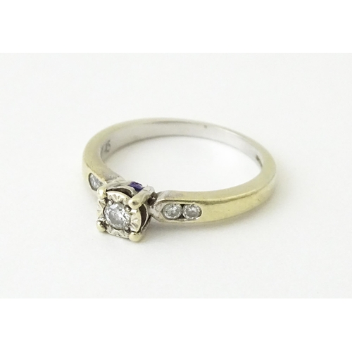 713 - A 9ct gold ring set with a central diamond flanked by further diamonds. Ring size approx. I