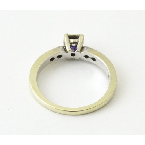 713 - A 9ct gold ring set with a central diamond flanked by further diamonds. Ring size approx. I