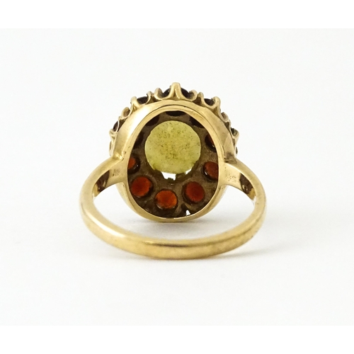 714 - A 9ct gold ring set with central opal bordered by garnets. Ring size approx. K 1/2