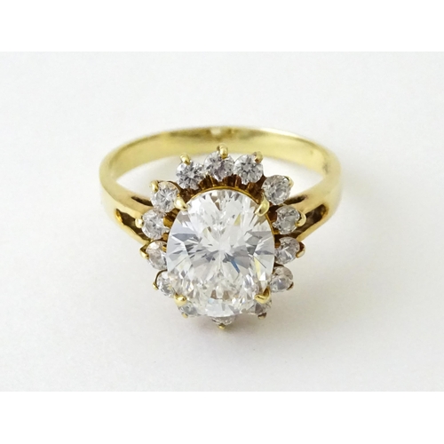 716 - A yellow metal dress ring set with central white stone bordered by further white stones. Ring size a... 