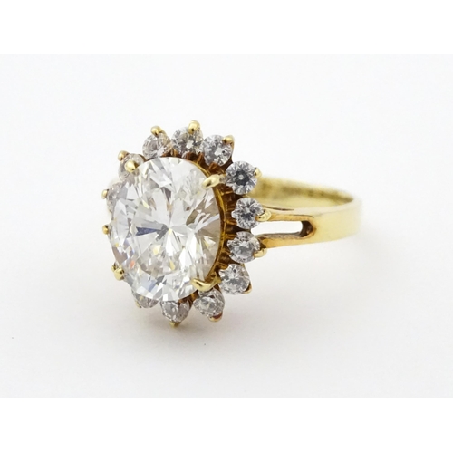 716 - A yellow metal dress ring set with central white stone bordered by further white stones. Ring size a... 